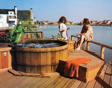 Man and woman on a deck with a hot tub.