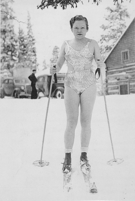 woman wearing swimming suit on cross country skis in the snow